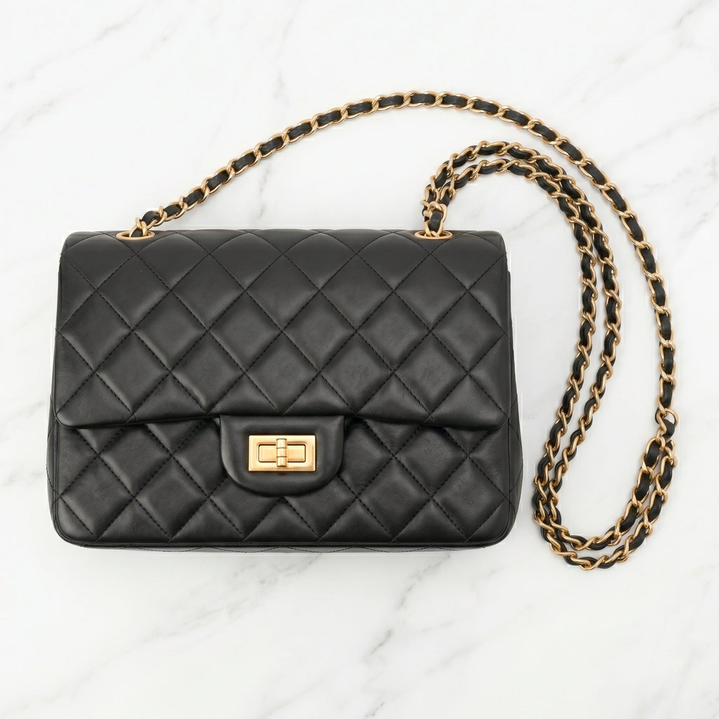 Black quilted handbag with a gold chain front