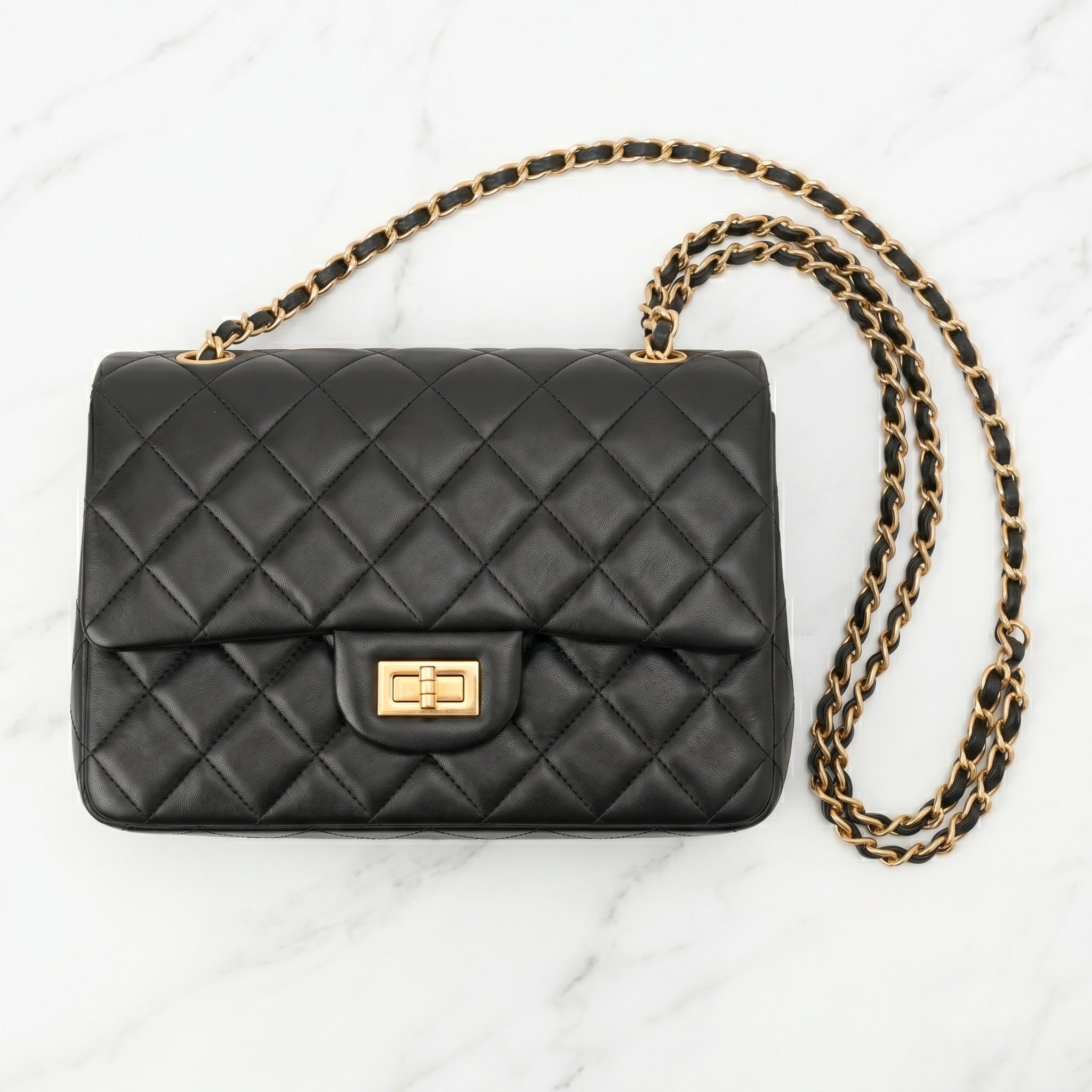 Black quilted handbag with a gold chain front
