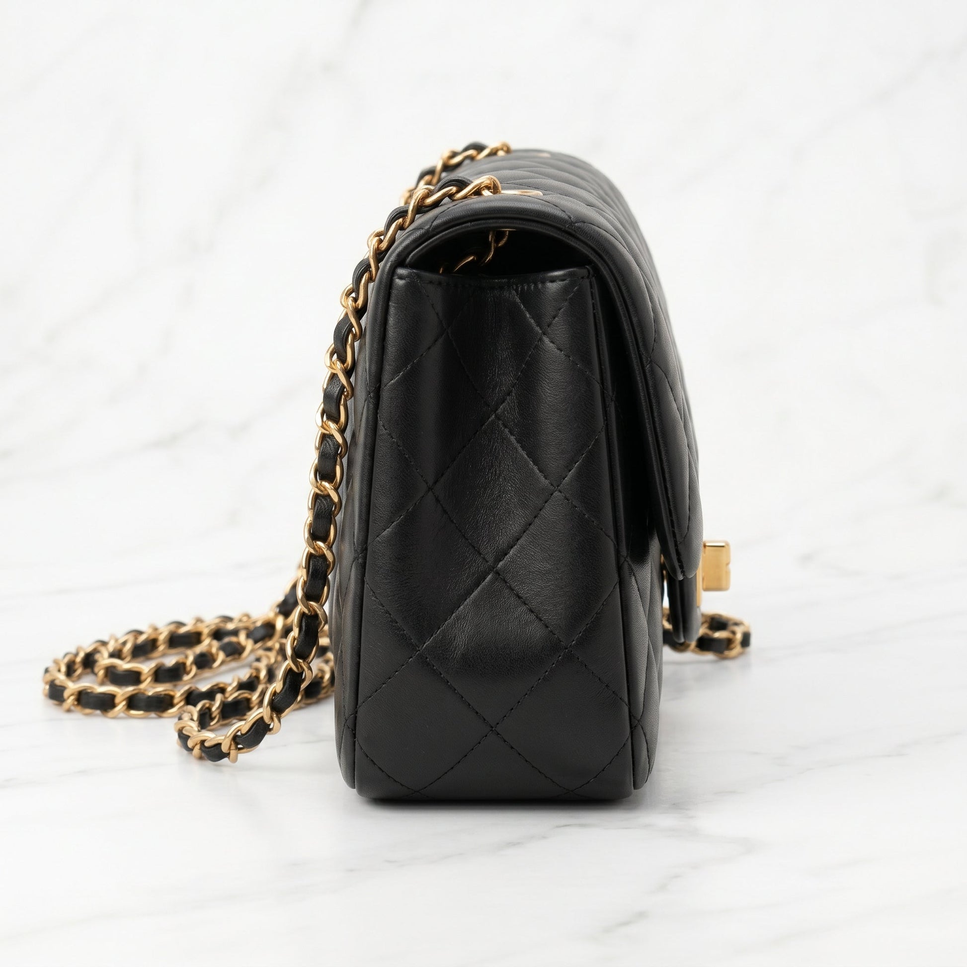 Black quilted handbag with gold chain side