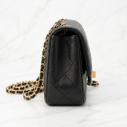 Black quilted handbag with gold chain side