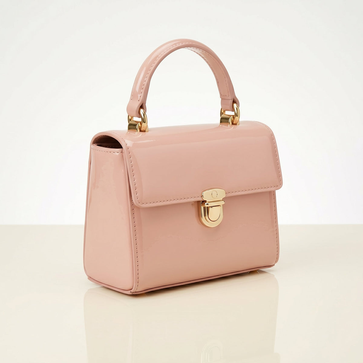 Pink handbag with gold accents on a light beige background