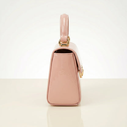 Pink handbag with gold accents on a light beige background