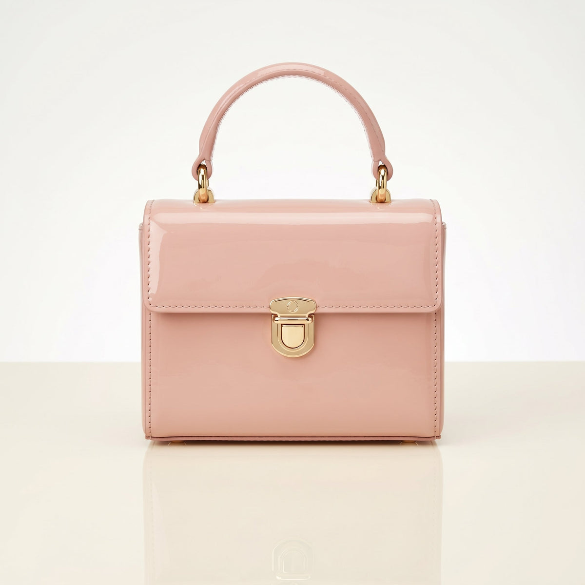 Pink handbag with gold accents on a light beige background
