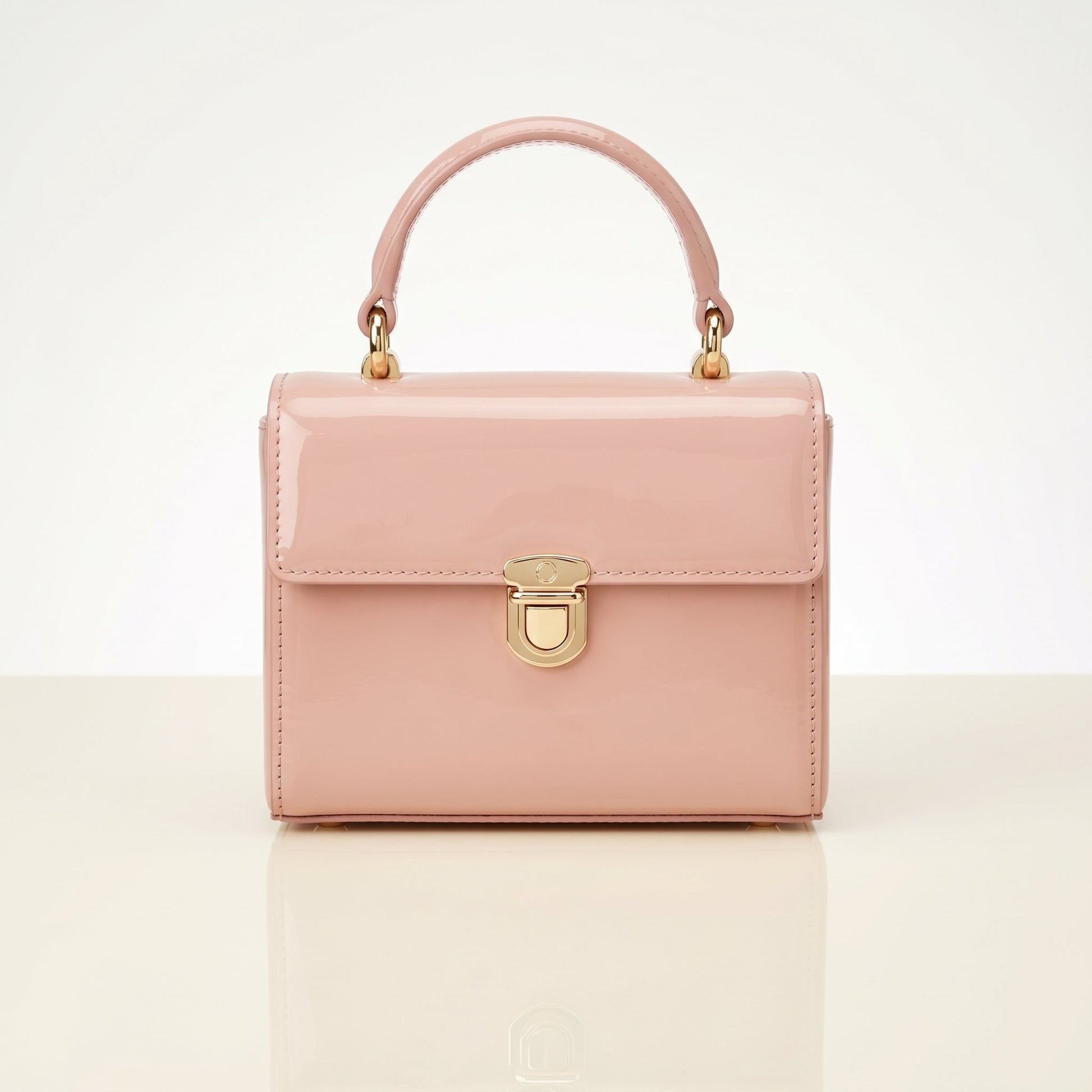 Pink handbag with gold accents on a light beige background