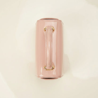 Pink handbag with gold handle on a beige top