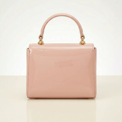 Pink handbag with gold handle on a light beige background