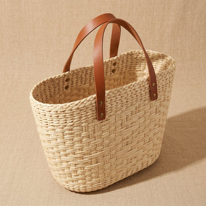 Woven basket with brown leather handles 